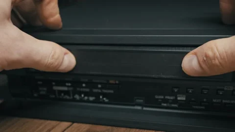 Hand Inserting VHS Tape Into Vintage VCR Player And Pressing Play Button Stock Footage 329835307