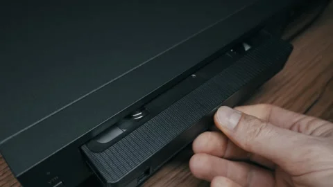 Hand Inserting a VHS Videocassette Tape into a Black VCR Player 스톡 동영상 329911030