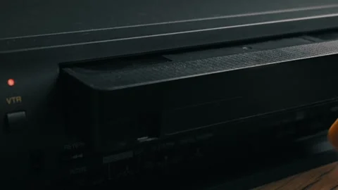 Hand Inserting a VHS Videocassette Tape into a Vintage VCR Player 스톡 동영상 329920079