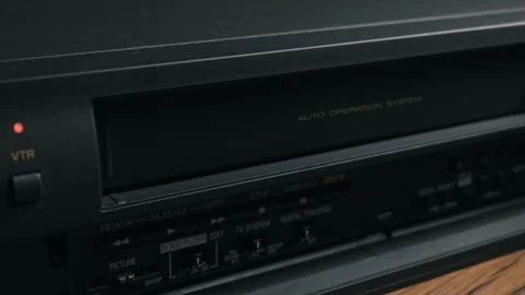 Hand Inserting a VHS Videocassette Tape into an Old VCR Player 스톡 동영상 329922759