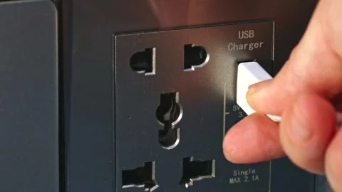 Hand inserting white power cord cable into electric usb charger plug socket Stock Footage 264967458