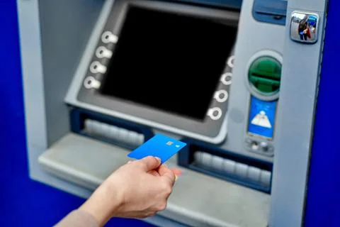 Hand inserts the card into the ATM Stock Photos