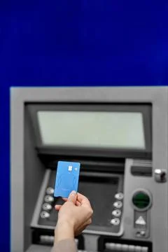 Hand inserts the card into the ATM Stock Photos