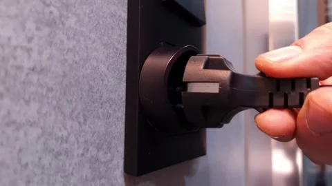 Hand inserts cord with plug from the electrical device to the socket Stock Footage 297087039