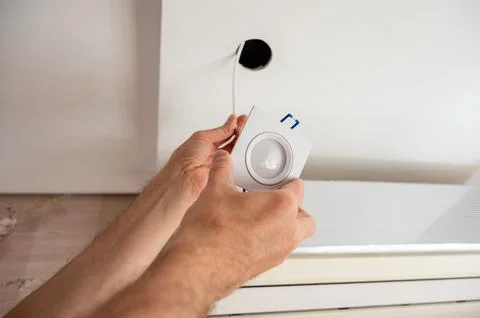 Hand inserts the lamp into the ceiling Stock Photos