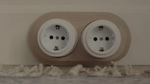 Hand inserts plug into socket, removes it and puts it nearby indoors Vidéo 113077291