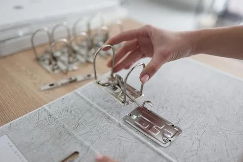 The hand inserts the ring mechanism into the folder Stock Photos