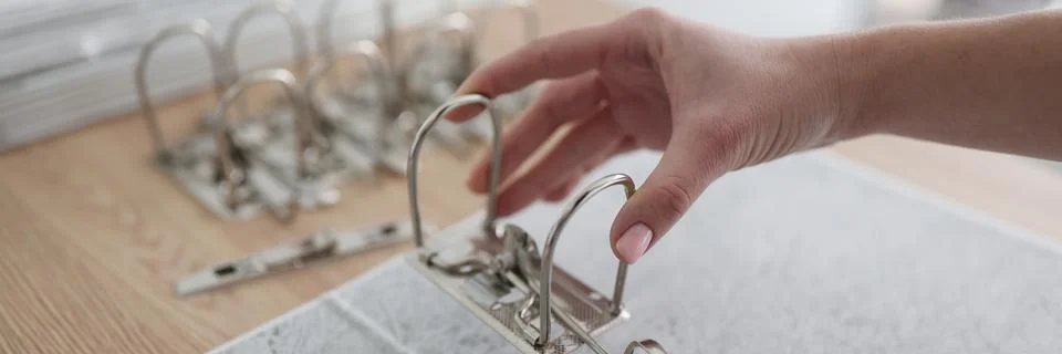 The hand inserts the ring mechanism into the folder 스톡 사진