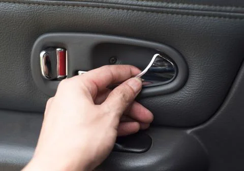 Hand on the inside car handle / Man hands to open door pressing button lockin Photos