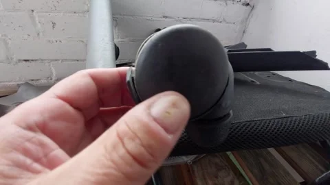 Hand inspecting and turning a dusty broken plastic caster wheel of an office cha Stock Footage 335397964