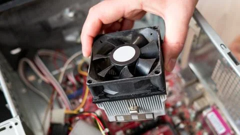 Hand inspecting a computer cpu fan in open desktop case Stock Photos