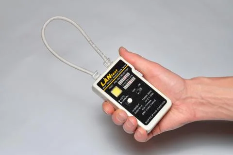 Hand installer keeps Ethernet LAN tester Stock Photos