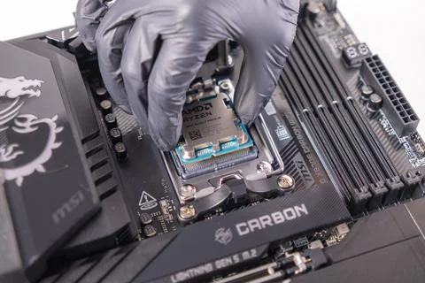 Hand installing an AMD RYZEN 7 9800X3D CPU into a MSI MEG X870E CARBON WIFI Foto stock
