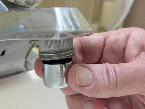 Hand Installing a Chrome Plumbing Fitting Beneath a Faucet Stock Photos