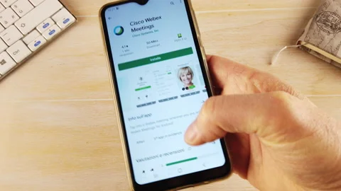 Hand installing the CISCO WEBEX MEETINGS app on the phone Video stock 144104546