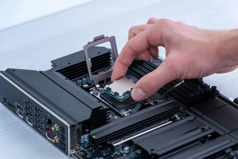 Hand installing desktop processor into motherboard socket, computer assembl.. Stock Photos
