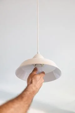 Hand installing led light bulb in ceiling lamp Stock Photos