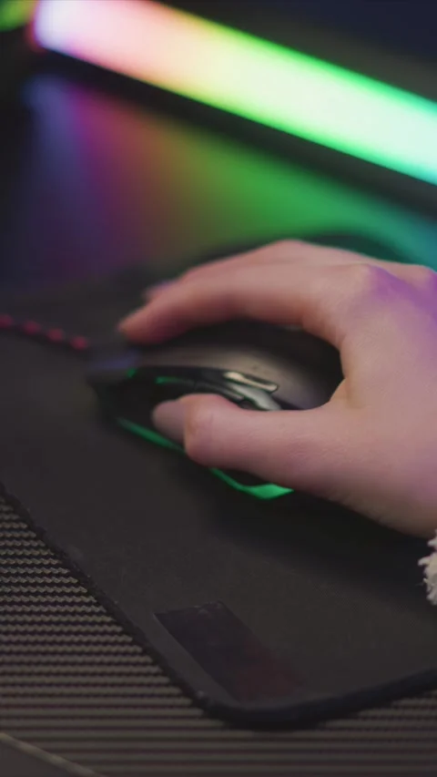 Hand Interacting with Computer Mouse on Wrist Rest Against Colorful LED Lighting Stockbeeldmateriaal 346770013