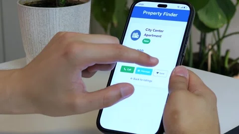 A hand interacts with a real estate app, saving a preferred home for later Stock Footage 315175398