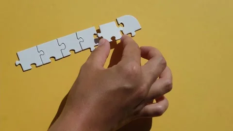 Hand join the piece of jigsaw puzzle to complete the line. Stock Footage 219396170