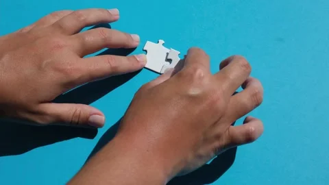Hand join the piece of jigsaw puzzle to complete the line. Stock Footage 219611762