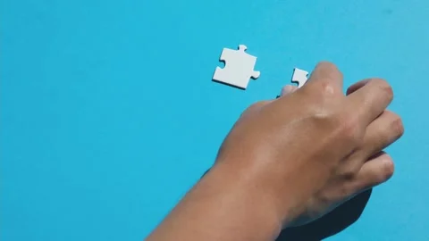 Hand join the piece of jigsaw puzzle to complete the line. Stock Footage 220479388