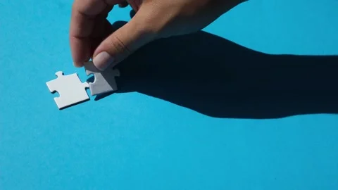 Hand join the piece of jigsaw puzzle to complete the line. Stock Footage 221423302