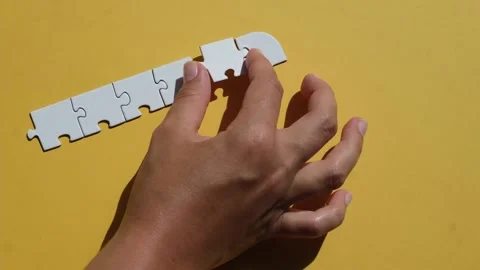 Hand join the piece of jigsaw puzzle to complete the line. Stock Footage 221615539