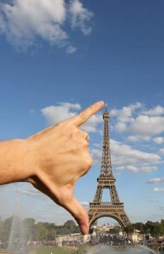 Hand that jokingly measures the Eiffel Tower with the span in Paris France Fotos de archivo