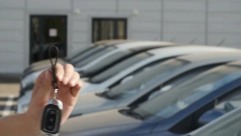 Hand with a key on the background of a row of new cars Stock-Footage 90430898