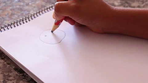The hand of a kid hand drawing a happy face on a plain white paper Stock Footage 49433666