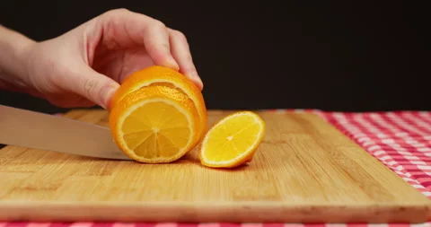 Hand with kitchen knife slicinglemon on board into round slices Stock Footage 234122536