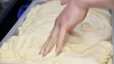 Hand kneading dough in container, progressive stages of mixing and texture Stock Footage 337229097