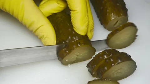 A hand with a knife cuts a pickled cucumber, close-up Vídeos de archivo 229593693