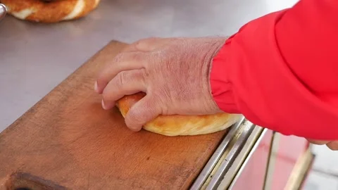 A hand with a knife cutting a bread , Stock Footage 338217593