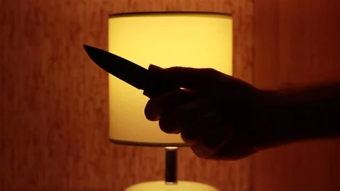 Hand with knife in front of green lamp 動画素材 83747902