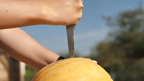 A hand with a knife pricks a pumpkin. a knife pierces a pumpkin close-up 스톡 동영상 253217681