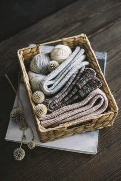 Hand knitting socks with yarn balls in a basket on a dark wooden background. Stock Photos