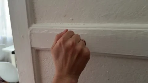 A hand knocks on a white wooden door Stock Footage 336524046