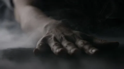 A Hand Lands on a Table Filled with Smoke Against a Black Background in Slow Stock Footage 270393101