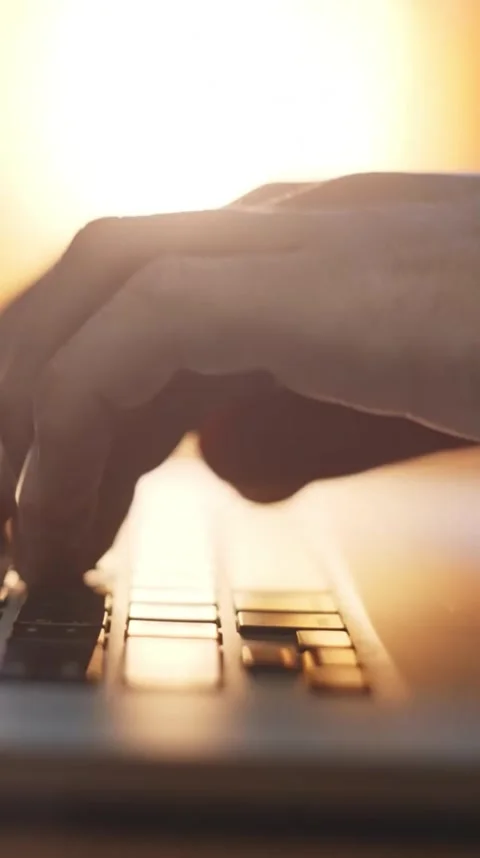 Hand on Laptop Keyboard with Warm Light in Background for Work Stock Footage 306459825