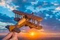 The hand launch toy plane on the background of a sunrise Photo