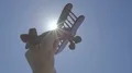 The hand launch a wood plane on the background of a bright sun 4k or 4k+ Resolution