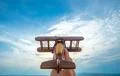 The hand launch a wooden plane on the blue sky background Photo