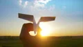 The hand launches the paper plane to the sky on the sunset background 4k or 4k+ Resolution