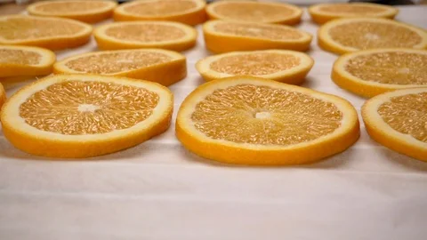 Hand lay orange slices on baking paper. Close up. Stock Footage 117467993