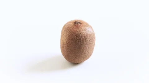 Hand lays a kiwi on the table Stock Footage 74499056