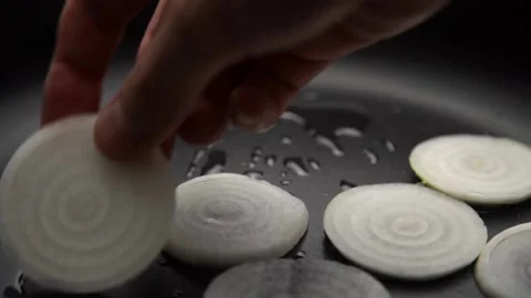 The hand lays out the onion in a frying pan Stock Footage 158543053