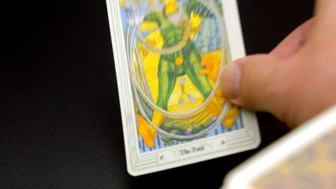 A hand lays out, Thoth Tarot, full major arcana cards on black tablecloth. Stock Footage 129757361