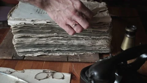Hand leafing through an old book on the table surrounded by vintage accessories Stock Footage 142464386